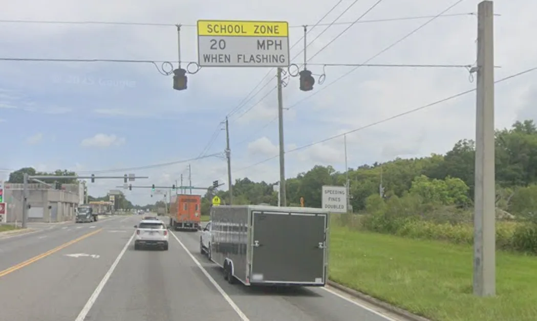 Overhead SCHOOL ZONE 20 MPH WHEN FLASHING sign with dark beacons on US 301 Lawtey